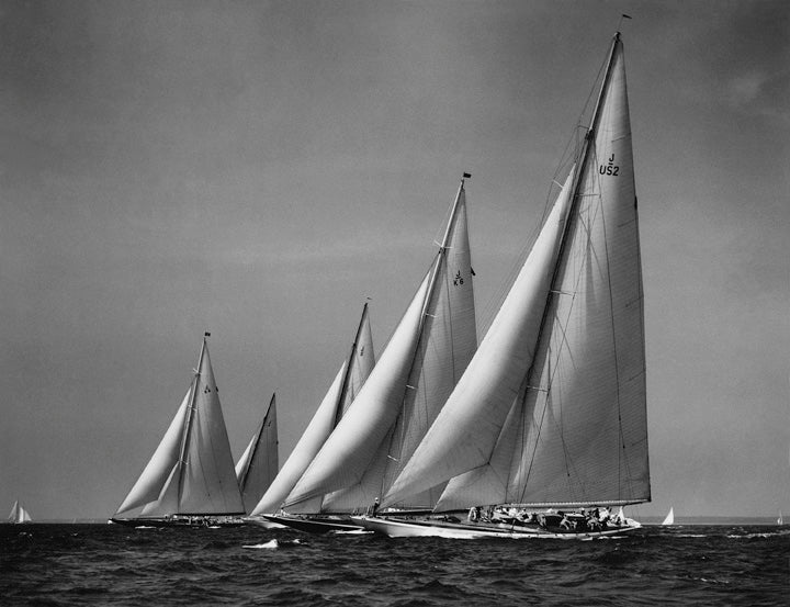 AT THE START, 1937 <br />An unforgettable moment in yachting history. Five of the 135-foot class J sloops with their 160-foot masts hit the starting line. From windward: Endeavor I, Rainbow, Ranger, Endeavor II, and Yankee.